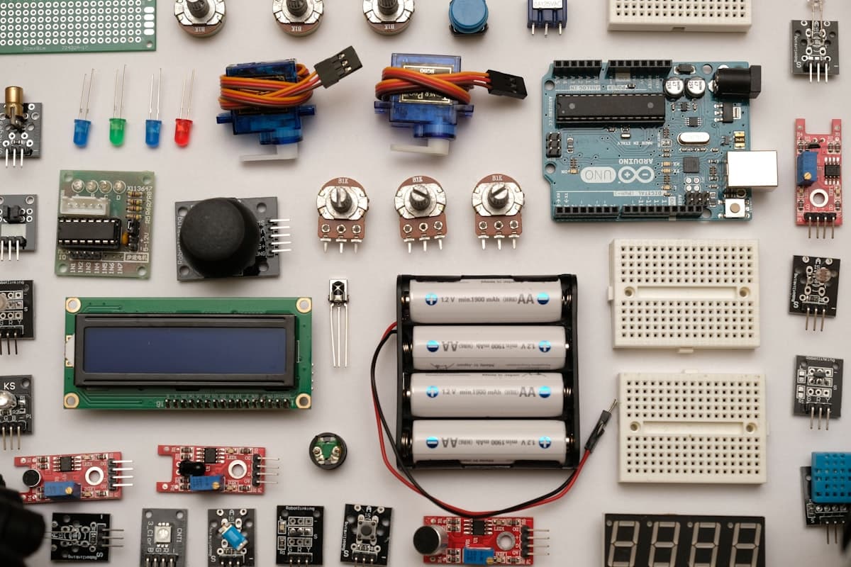 A flat lay of IoT components - a microcontroller board, breadboards, sensors, and wiring