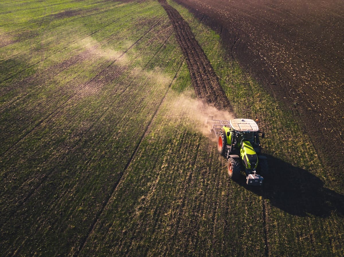 A tractor equipped with connected technology working in a green field