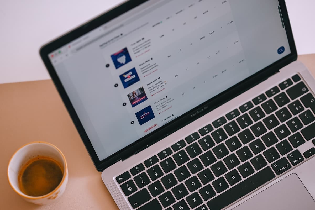 A laptop displaying a personalized content feed beside a cup of coffee