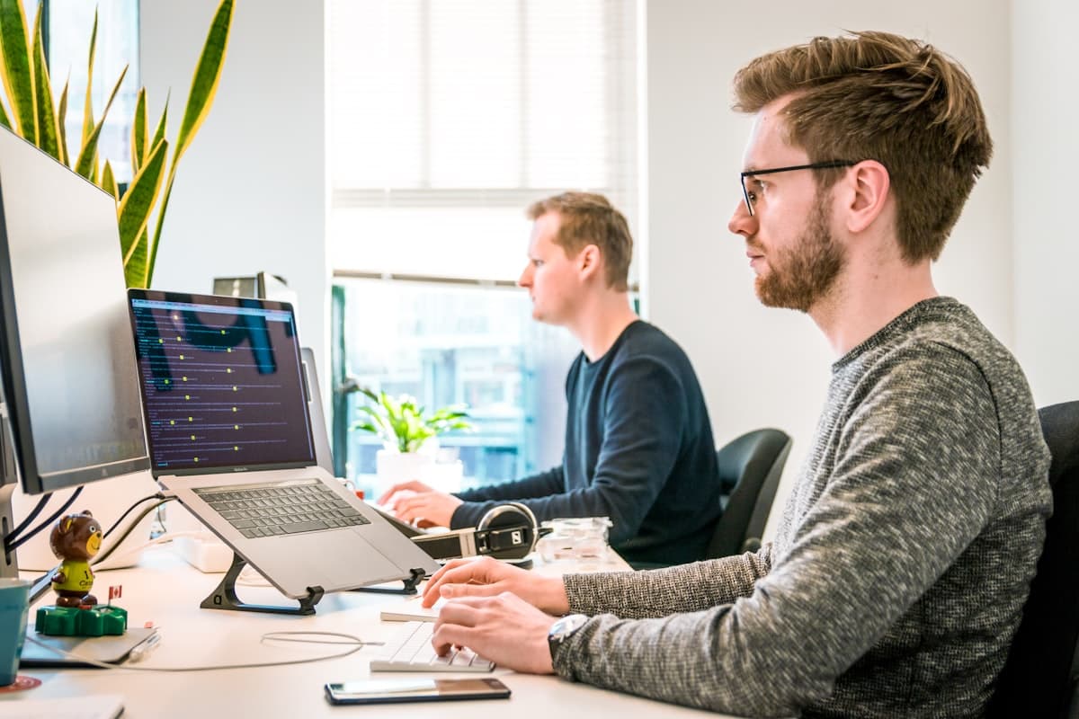 Two developers working at their laptops in an office