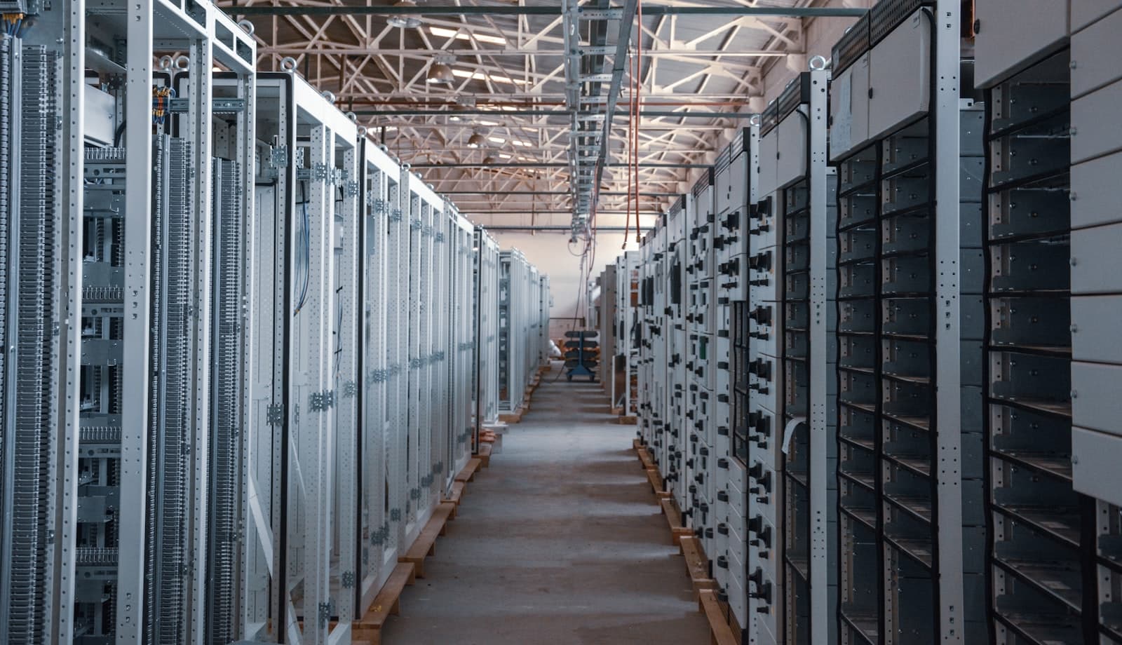 A corridor lined with rows of server equipment racks