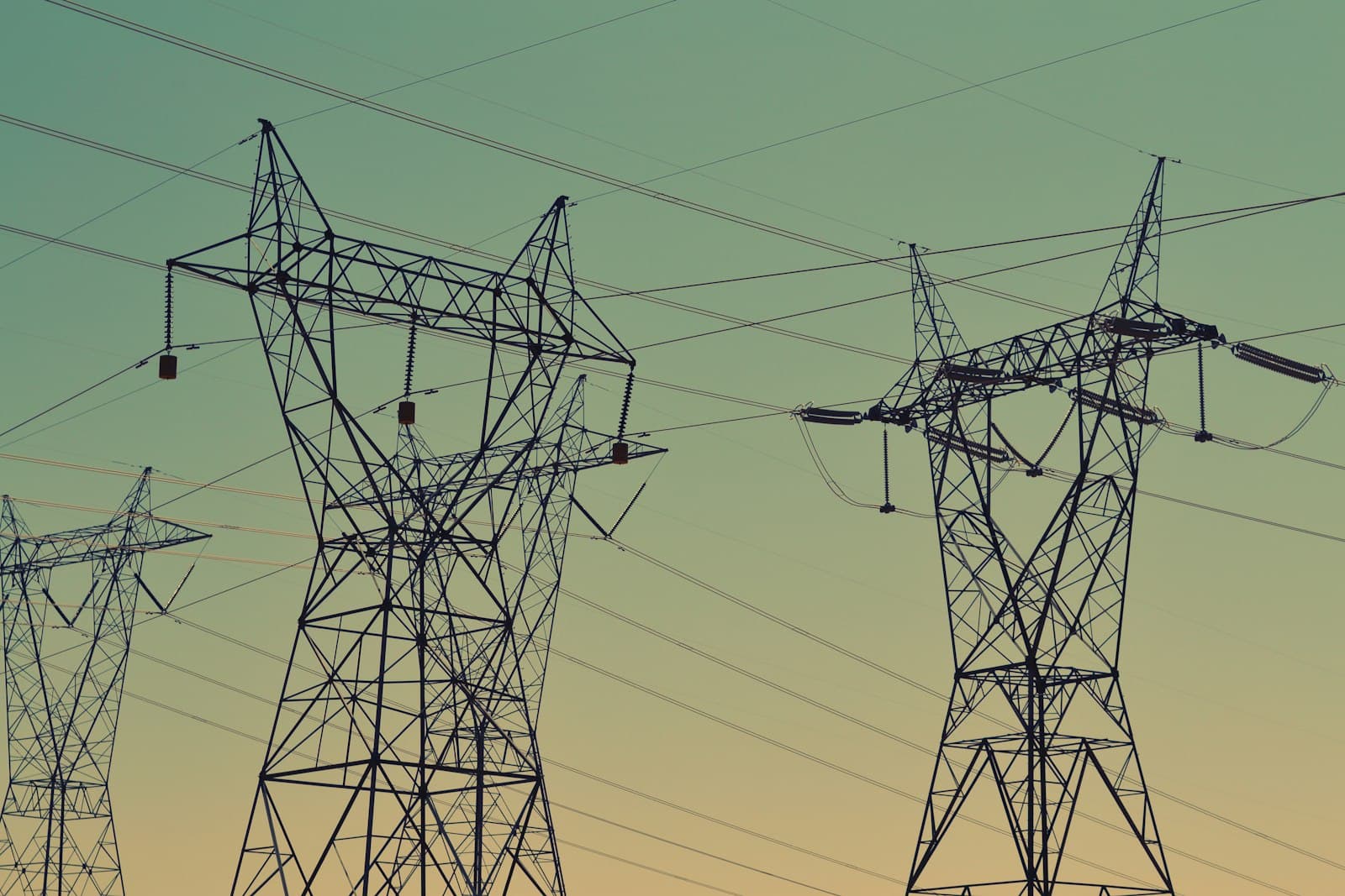 Electrical transmission towers against a sky at dusk